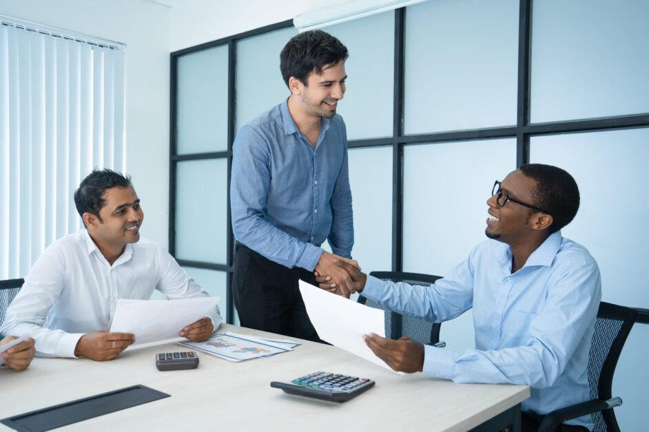 Friendly Caucasian and Afro American business people shaking hands. Mix raced colleagues greeting each other at meeting. International partnership and meeting concept